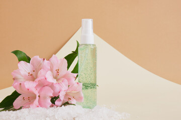 mock up cosmetic bottle with green gel for skin care and sea salt on beige background