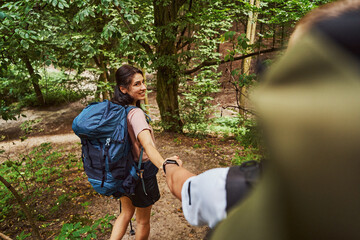 Jolly young woman enjoying romantic hiking with boyfriend