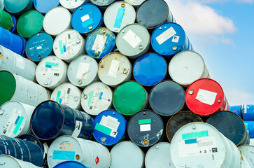 Old chemical barrels with flammable liquid warning label . Steel oil tank. Toxic waste in metal...
