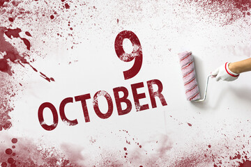 October 9th. Day 9 of month, Calendar date. The hand holds a roller with red paint and writes a...