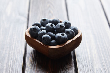 Bowl with blueberries on wooden table