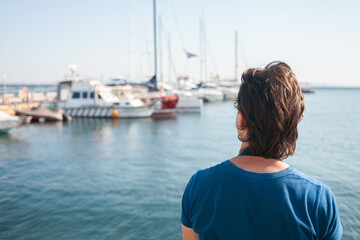 Fototapeta premium Tourist in seaport. Yachts in the parking lot, seaport in Odessa, Black Sea. Sailing, rich lifestyle, beach holidays. Business rental of boats, riding tourists on the waves. sunny day, wind