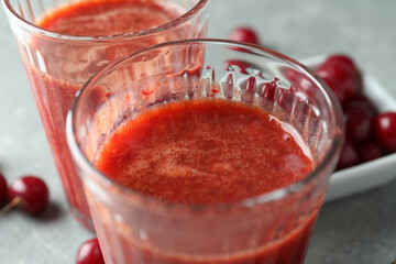 Glasses of cherry smoothie and ingredients, close up