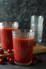 Glasses of cherry smoothie and ingredients on dark textured table