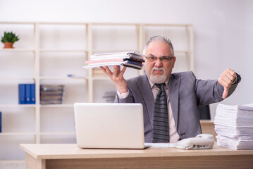 Old male employee working at workplace