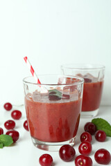 Glasses of cherry smoothie and ingredients on white table