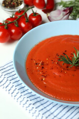 Gazpacho soup and ingredients on white background
