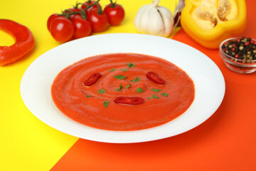 Gazpacho soup and ingredients on two tone background