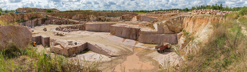 Panorama of operating quarry of red granite in summer day © An-T