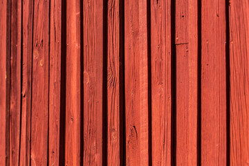 Schwedische rote Hausfassade aus Holz. Gerade senkrechte Linien. Hintergrund. Swedish red wooden house facade. Straight vertical lines. Background.