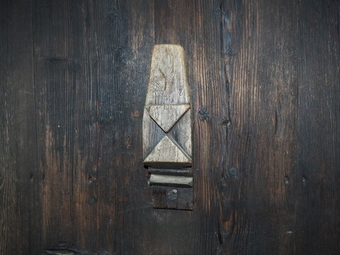 old carved wooden doorknob. A traditional rustic pattern or ornament carved with a knife on a wood surface. Serbia, the village of Trshich, the place where Vuk Karadzic lived