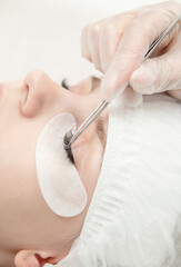 Obraz na płótnie Canvas Close up professional procedure of eyelash extension in the clinic