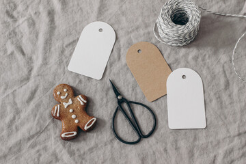 Christmas still life. Blank paper gift tags, labels mockups. Gingerbread cookie, black vintage...
