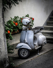 old vintage scooter with flowers and stairs in the background