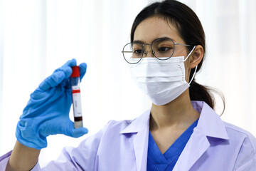 Scientist holding Coronavirus covid-19 infected blood sample tube DNA testing of the blood in the laboratory with blood sample collection tubes and syringe Coronavirus Covid-19 vaccine research.