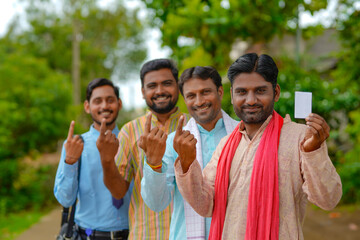 Young Indian farmers showing finger after voting with officers.
