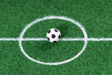 Fototapeta na wymiar Black and white soccer ball in the center of the soccer field, decoration mini football.