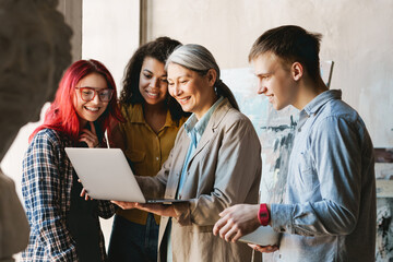 Mature teacher using laptop while talking with her students in art school © Drobot Dean