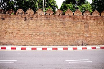Antique brick wall background ( Tha pae gate ) and street in Chiang Mai of  Thailand