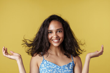 Young hispanic woman smiling and holding copyspace