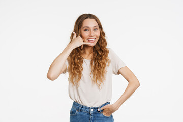 Fototapeta premium Young ginger woman in t-shirt smiling and making handset gesture