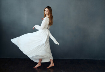 Fototapeta na wymiar Woman in white dress dance movement performing dark background