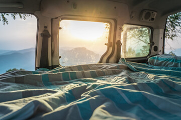 Bed in a mini camper van parked in an amazing mountainous landscape. Travel, sport and nature...