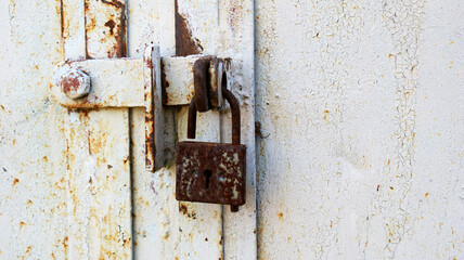 background of very old metal rusty grey garage door with handle and barn lock