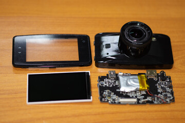 Parts of Car camcorder or Dashboard camera (Car Camera) are separated for repair on the wood board