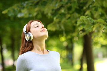 Woman wearing headphones meditating listening audio guide
