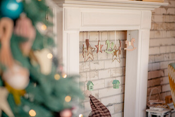 Christmas background with copy space and place for text. Decorated Christmas fireplace with a garland of wooden eco toys on the background of the bokeh of the Christmas tree