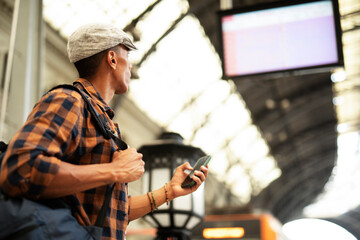 Happy young man waiting for the train. African man waiting in a subway.