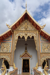 View of Viharn Luang or main vihara facade with beautiful golden wood carving at famous landmark Wat Phra Singh buddhist temple, Chiang Mai, Thailand