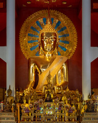 View of main golden Buddha and smaller gilded statues inside Viharn Luang or main vihara at famous...