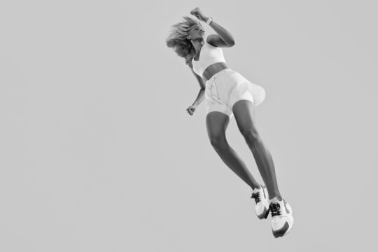 Profile picture of inspired energetic caucasian female in sportswear running and jumping. The concept of movement. Black and white photo of a sports girl in a jump.