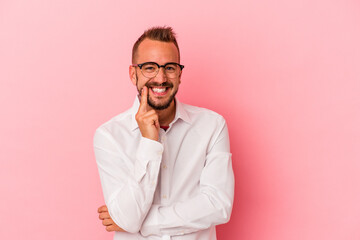Fototapeta premium Young caucasian man with tattoos isolated on pink background smiling happy and confident, touching chin with hand.