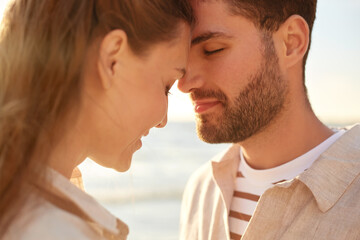 leisure, relationships and people concept - happy couple with closed eyes on summer beach