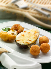 Berenjena rellena de pescado y bechamel , gambas rebozadas y croquetas de bacalao. Eggplant stuffed with fish and béchamel, battered prawns and cod croquettes.