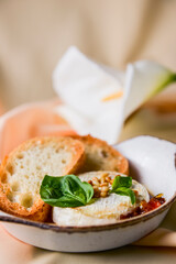 Baked camembert with sauce and toast served in a white bowl. Delicious dinner idea