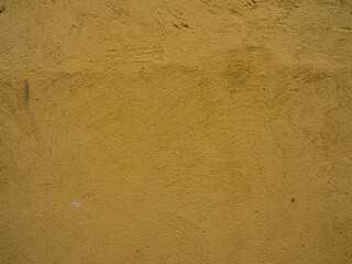 Fototapeta na wymiar The texture of a plastered yellow wall