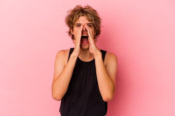 Young caucasian man with make up isolated on pink background shouting excited to front.