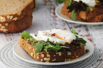 Homemade sandwiches with pesto, green salad and poached eggs