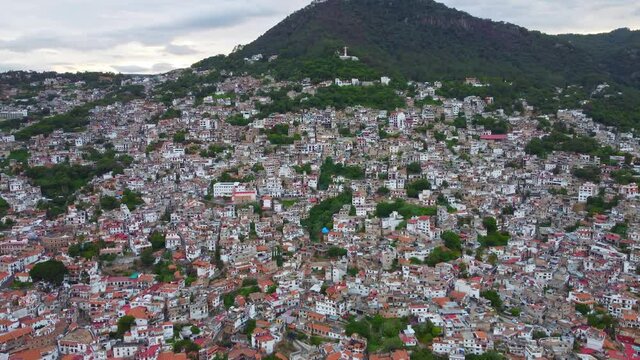 Taxco de Alarcon, Mexico. Aerial dolly in over the hillside homes and terraced buildings. Wide angle view
