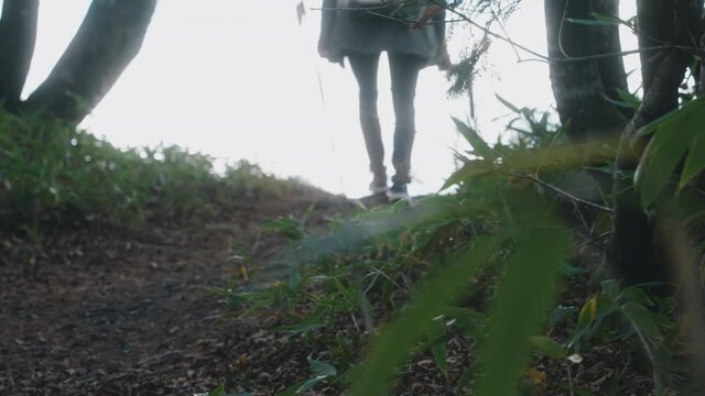 Image Of A Teenage Girl In Jeans And Sneakers Walking In The Wilderness At Daytime. slow motion