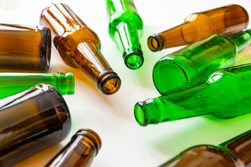 Empty beer or beverage bottles on white surface. Reuse and recycling of glass. Waste.
