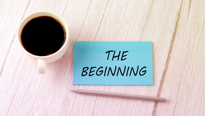 THE BEGINNING text on the blue sticker with cofee and pen