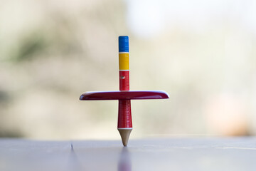 Colorful wooden peg-top or a teetotum on a blurred background