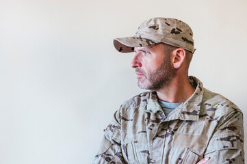 Fototapeta premium Caucasian man in camouflaged army uniform crossing arms