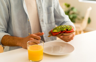 Young mixed race man having breakfast in his kitchen