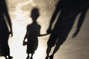Blurry shadow silhouette of a little girl walking hand in hand with a father